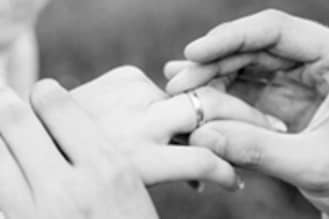 A person putting a ring on someone’s finger